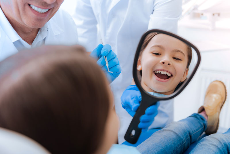 child smiling brightly with dental treatment