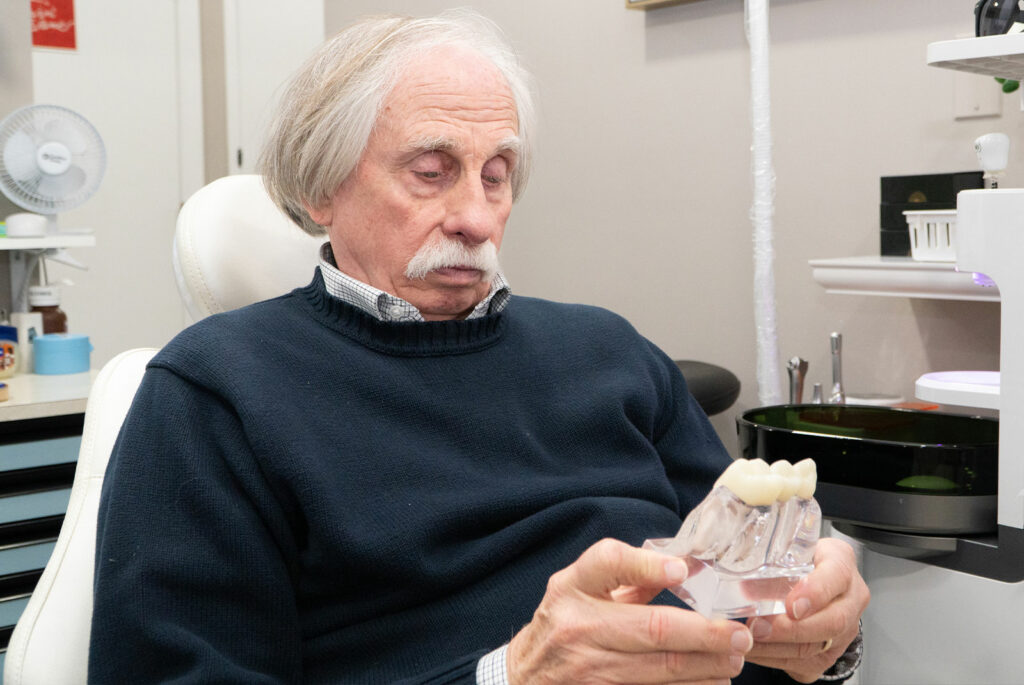patient holding a dental implant model within the dental center
